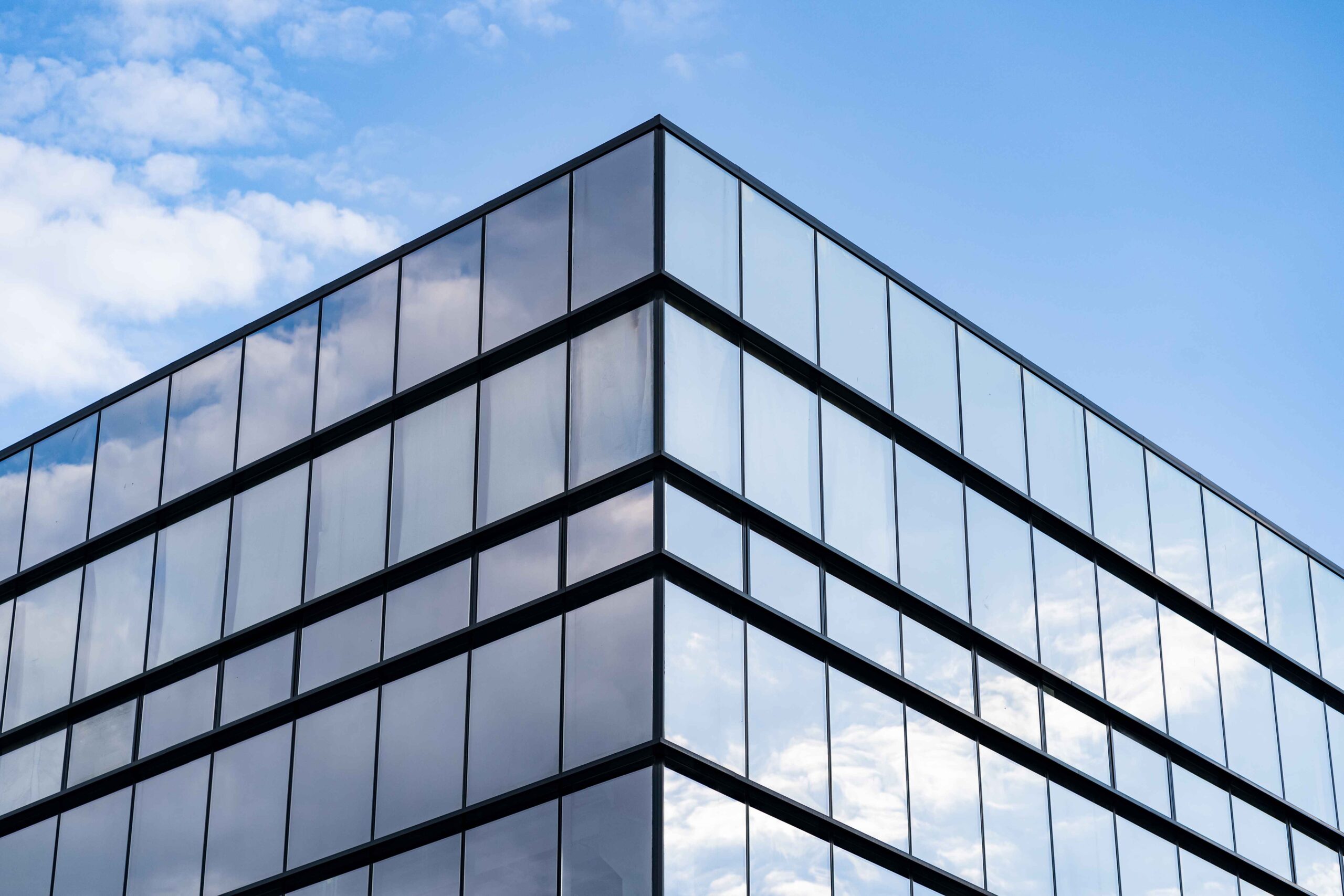 modern-glass-building-architecture-with-blue-sky-clouds_11zon (1)