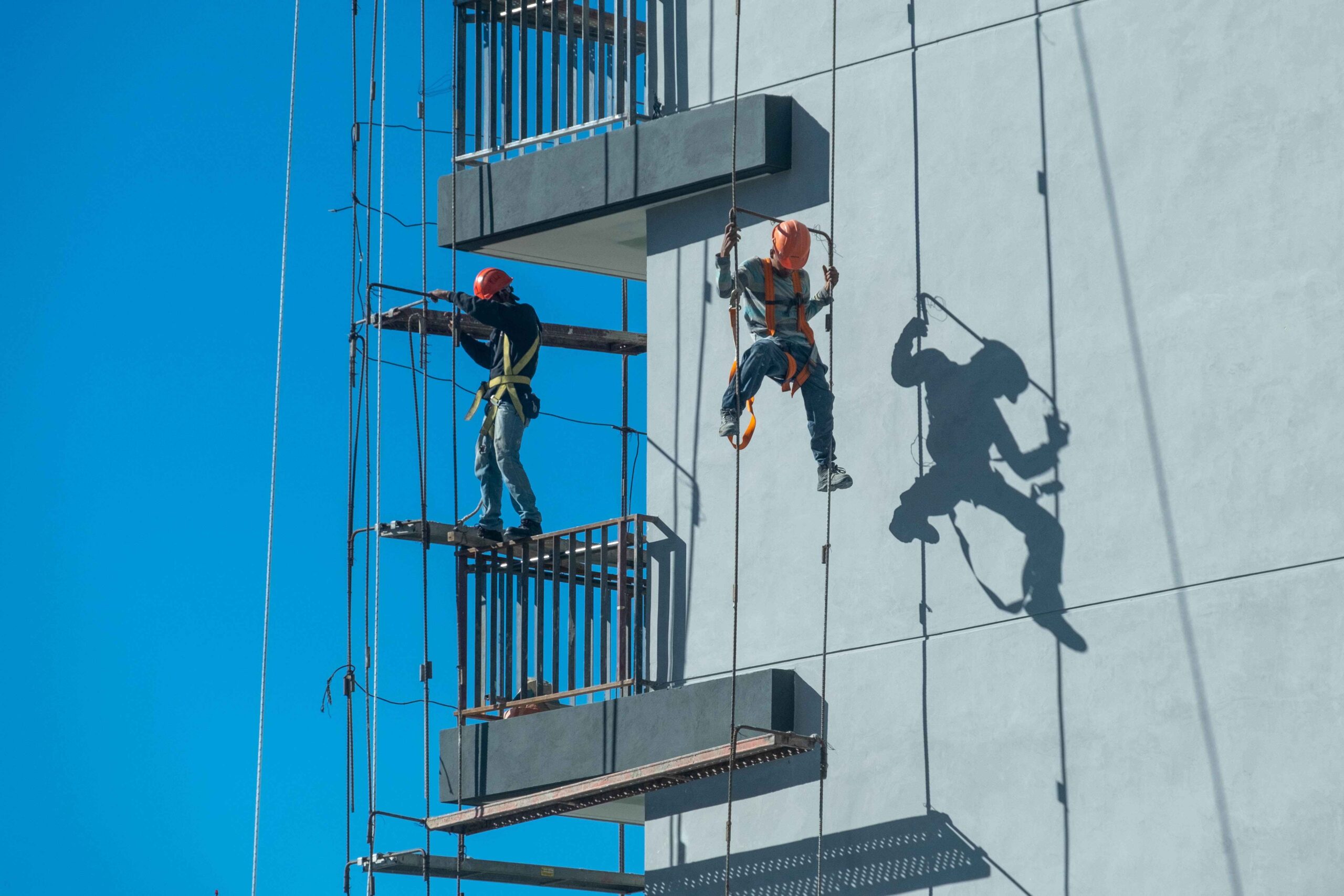 couple-workers-fixing-climbing-scaffolding-while-following-all-safety-measures_11zon